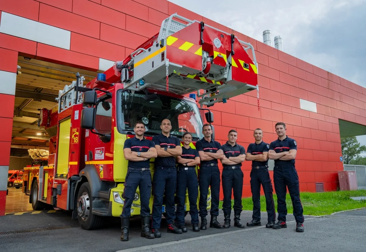 L'équipe d'organisation en tenue devant un fourgon du centre d'incendie et de secours de Bruges